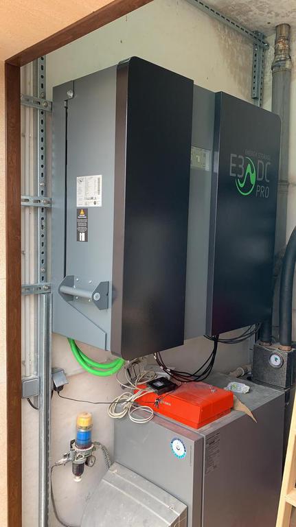 Gran sistema de calefacción gris y negro en una habitación, con varias tuberías y cables conectados.