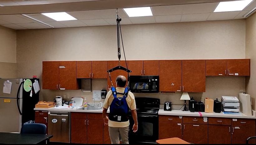 A man with a backpack is standing in a kitchen