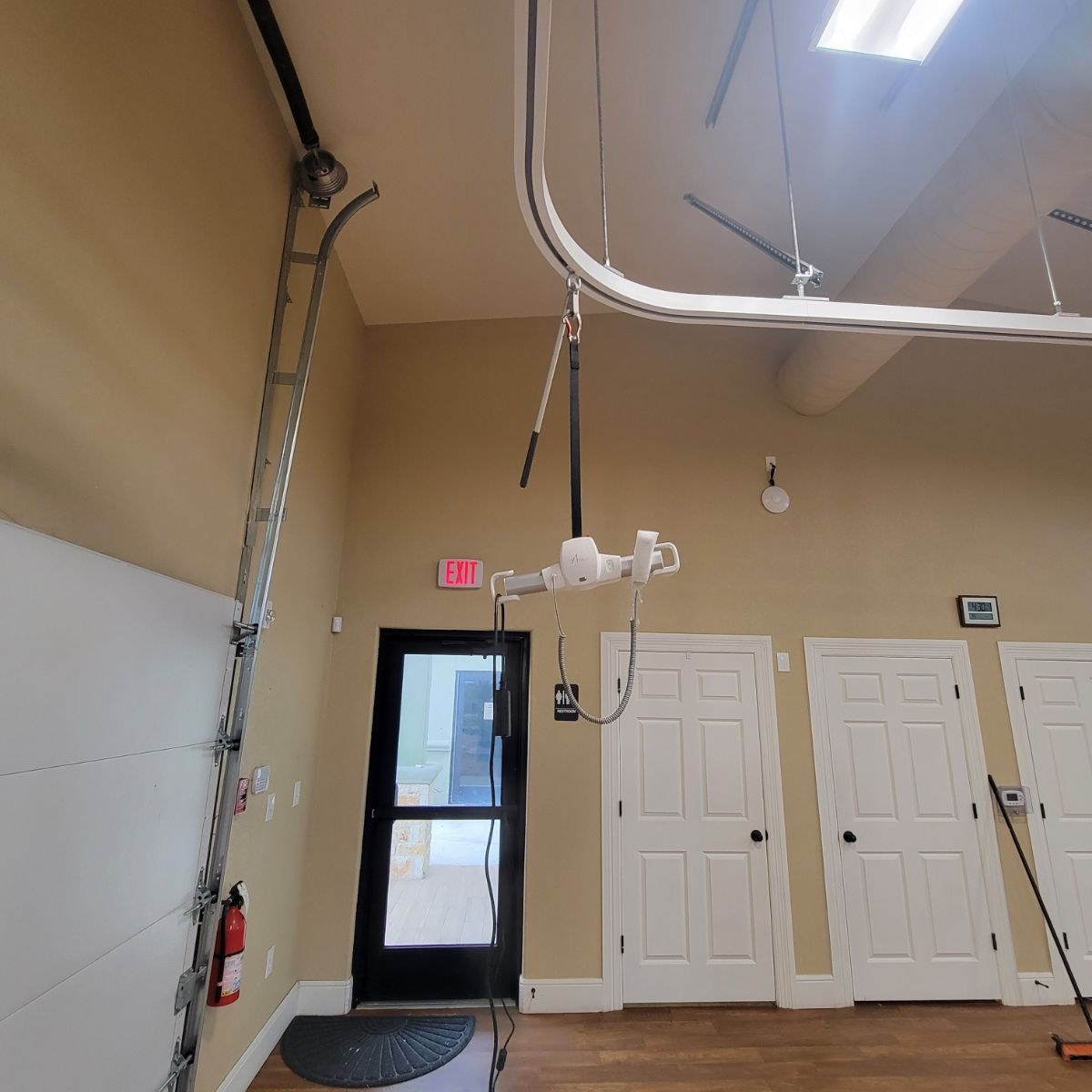 A room with a ladder and a lift hanging from the ceiling.