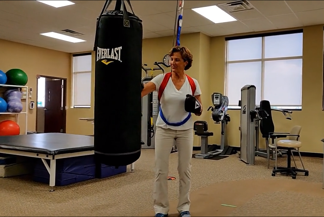 Woman wearing safety harness doing a boxing activity