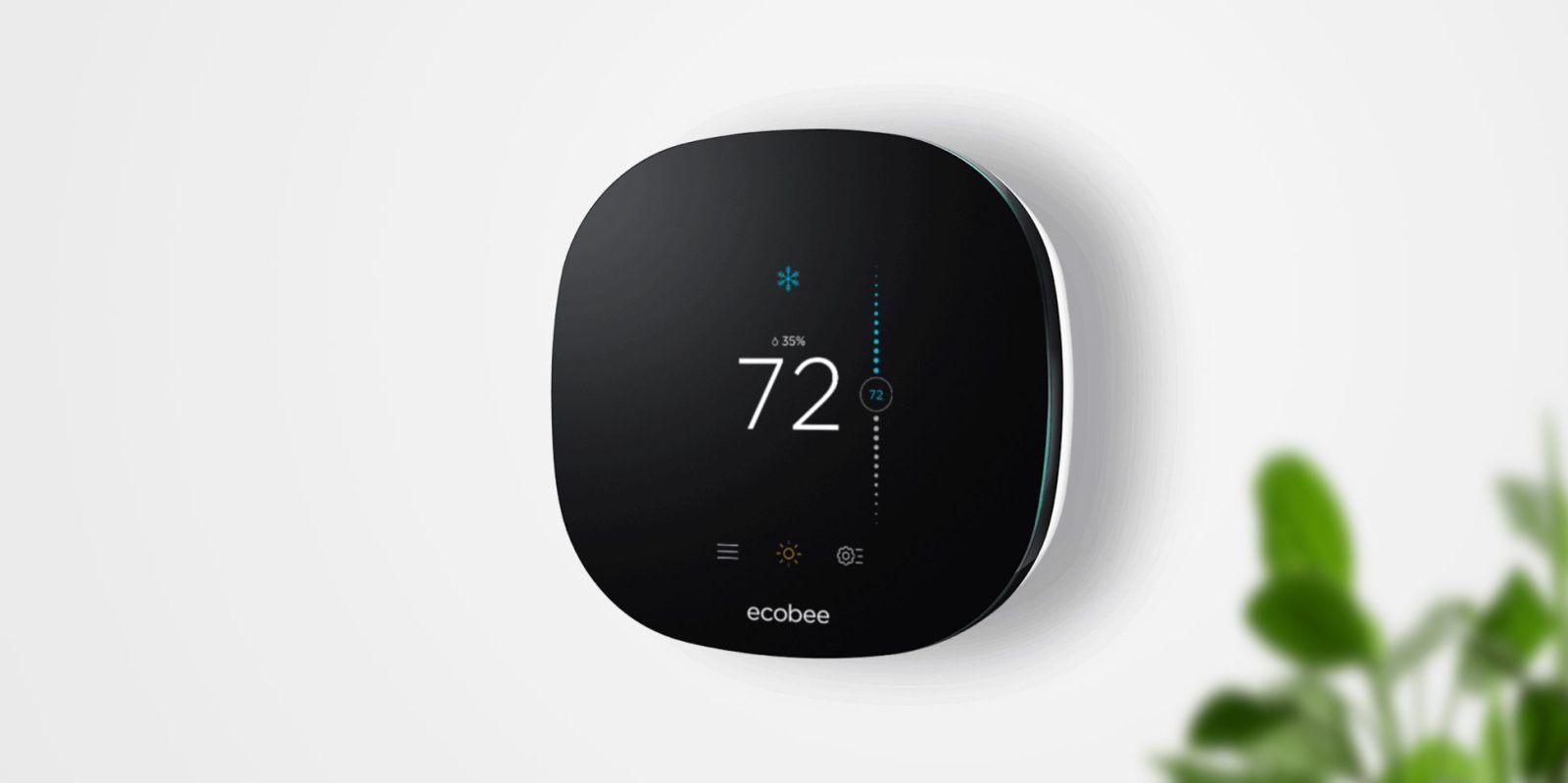 Smart thermostat displaying 74 degrees on a white wall.