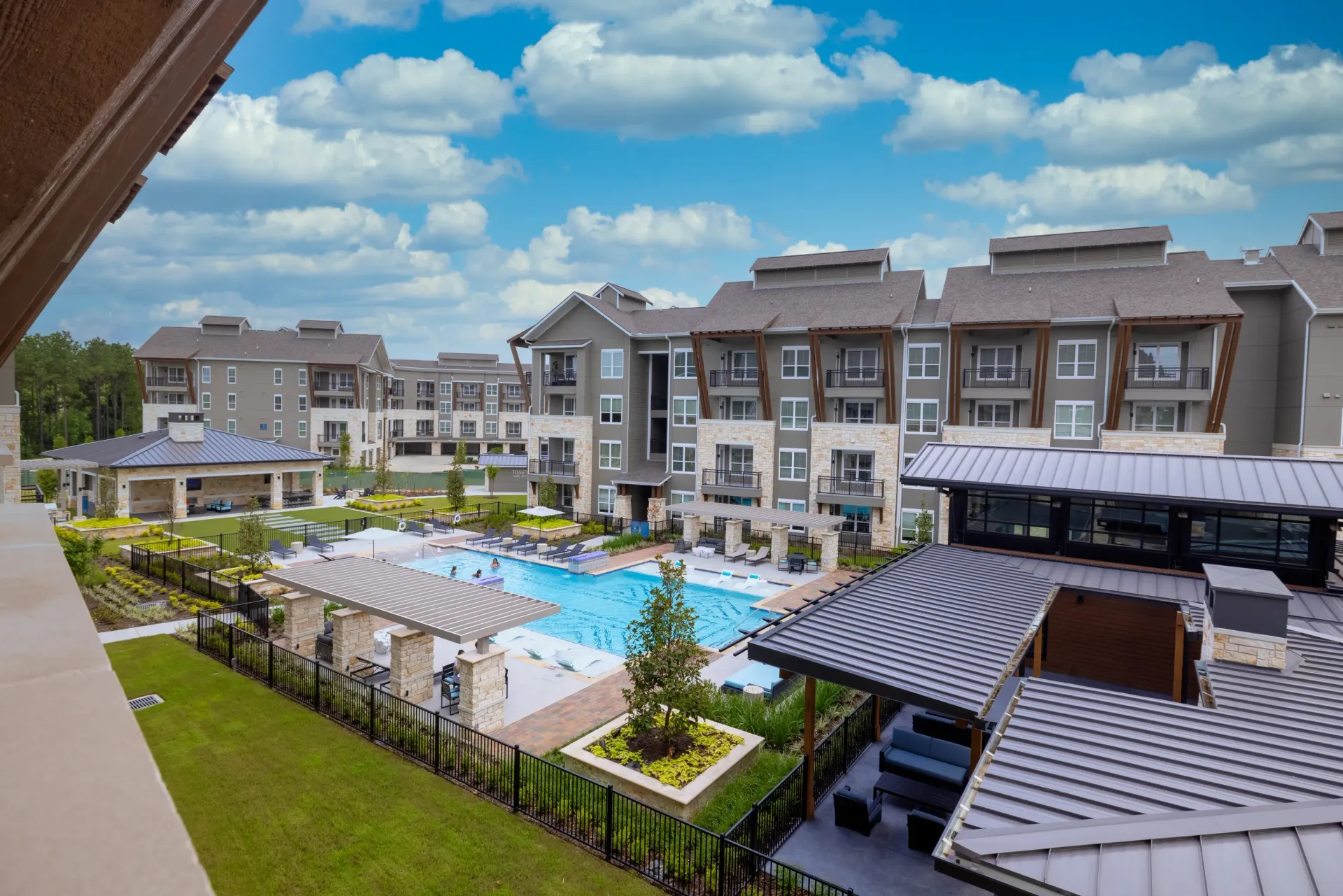 Resort-style swimming pool and outdoor lounge area at a modern apartment complex.