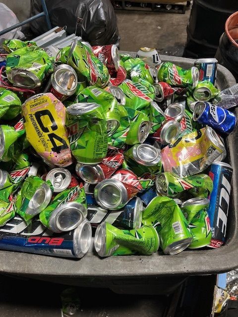 A pile of crushed aluminum cans in a bin.