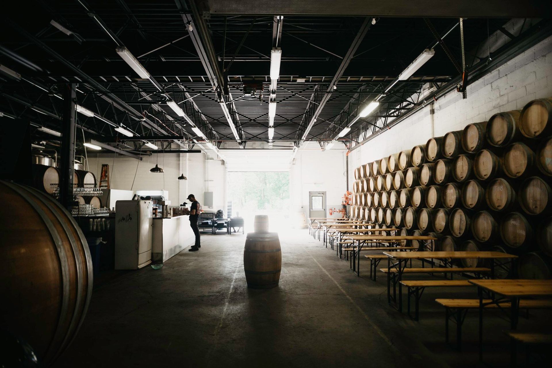 A warehouse filled with lots of barrels and tables.