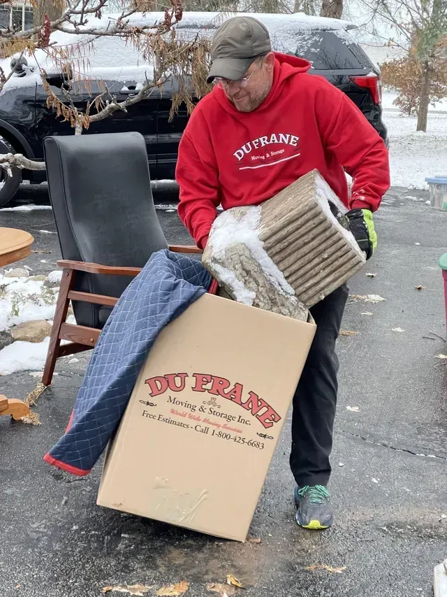 Man in red hoodie holds box labeled 