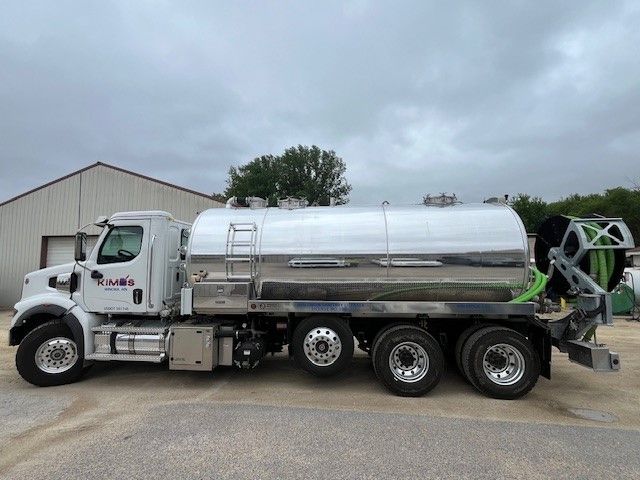 A vacuum truck is pumping water into a septic tank.