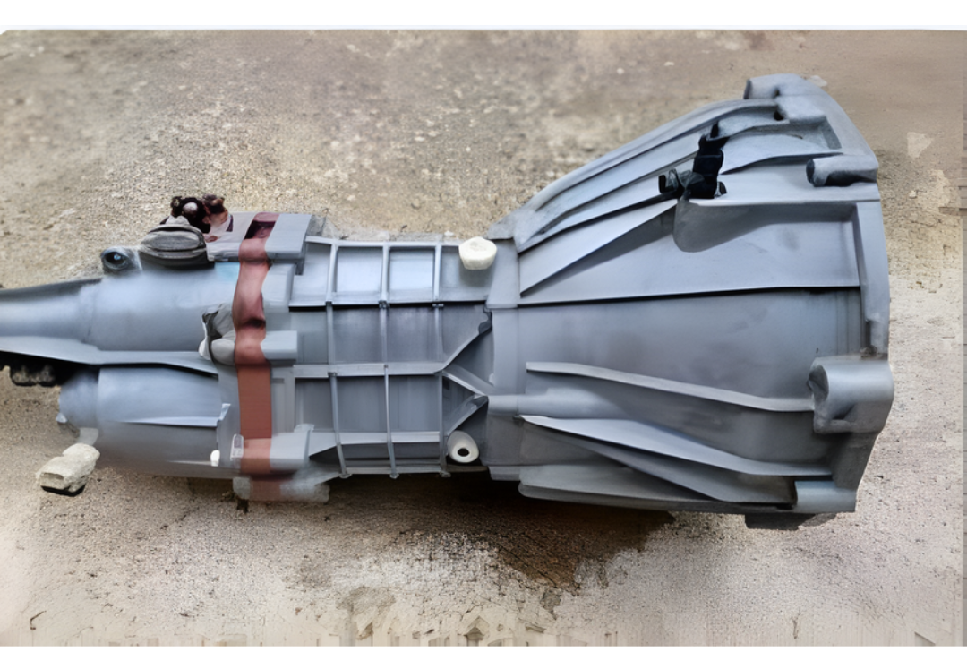 Clean Mahindra Scorpio gearbox lying on a concrete surface with the casing and bolt pattern clearly visible.
