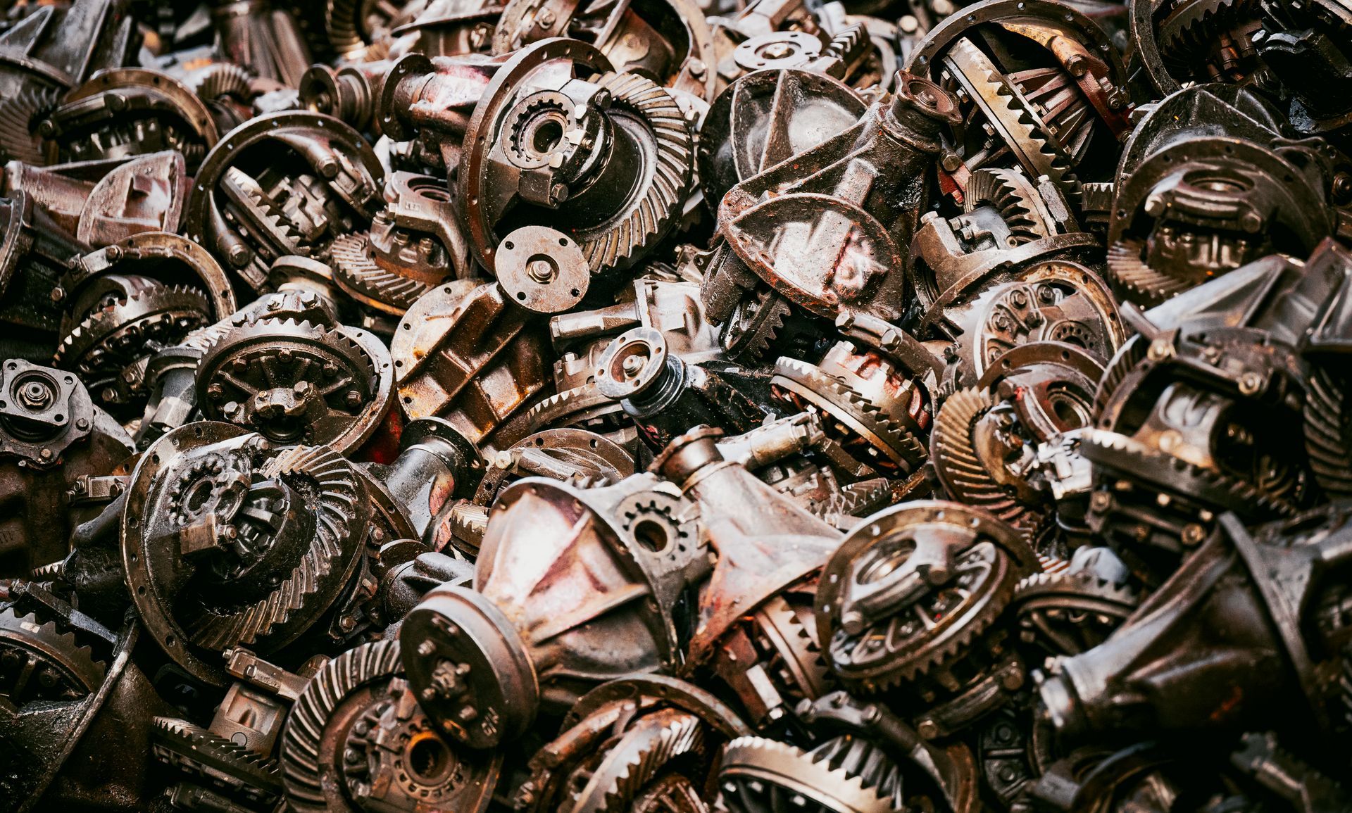Pile of used gearbox parts and differential components.