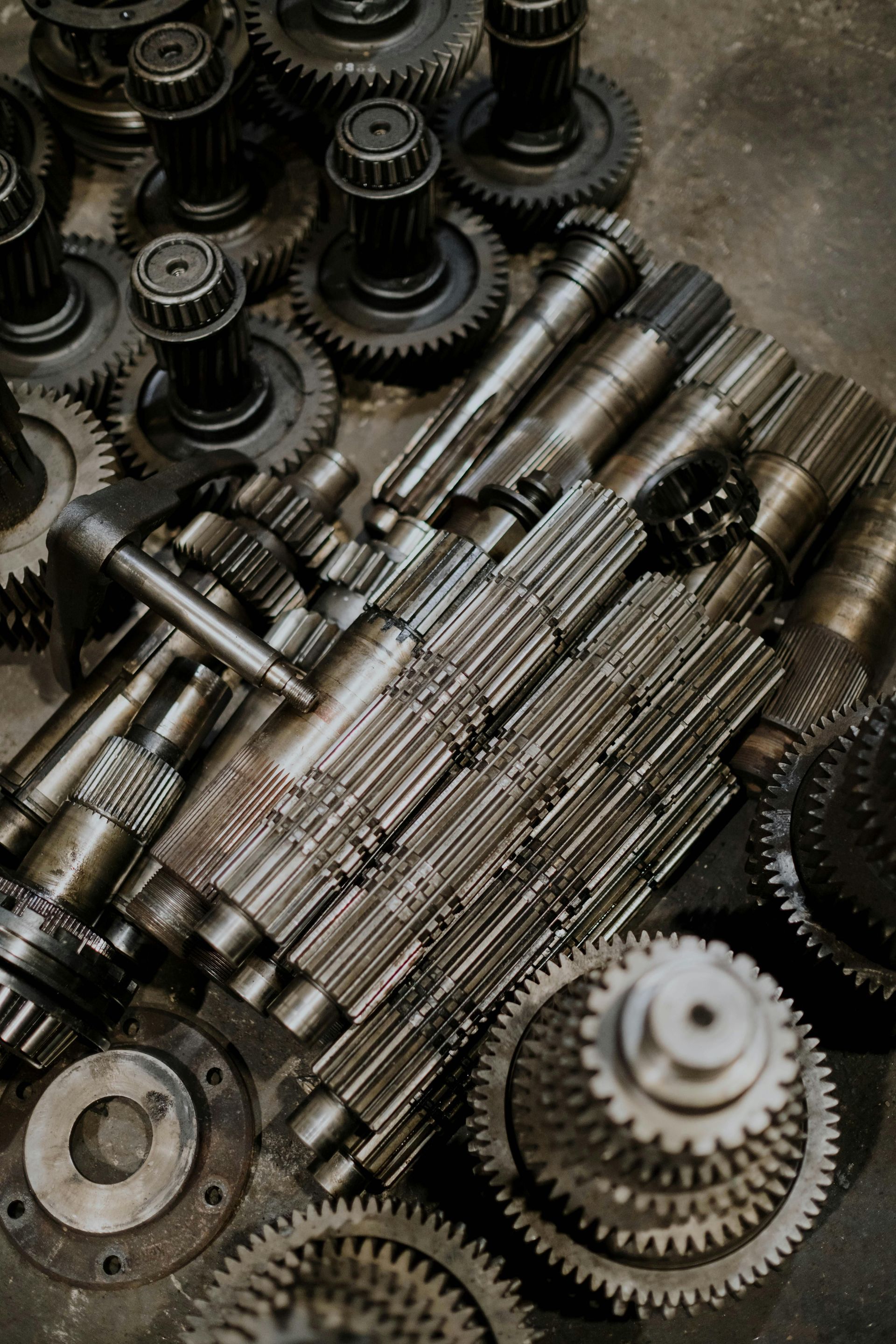 Gearbox shafts and metal gears laid out for repair.