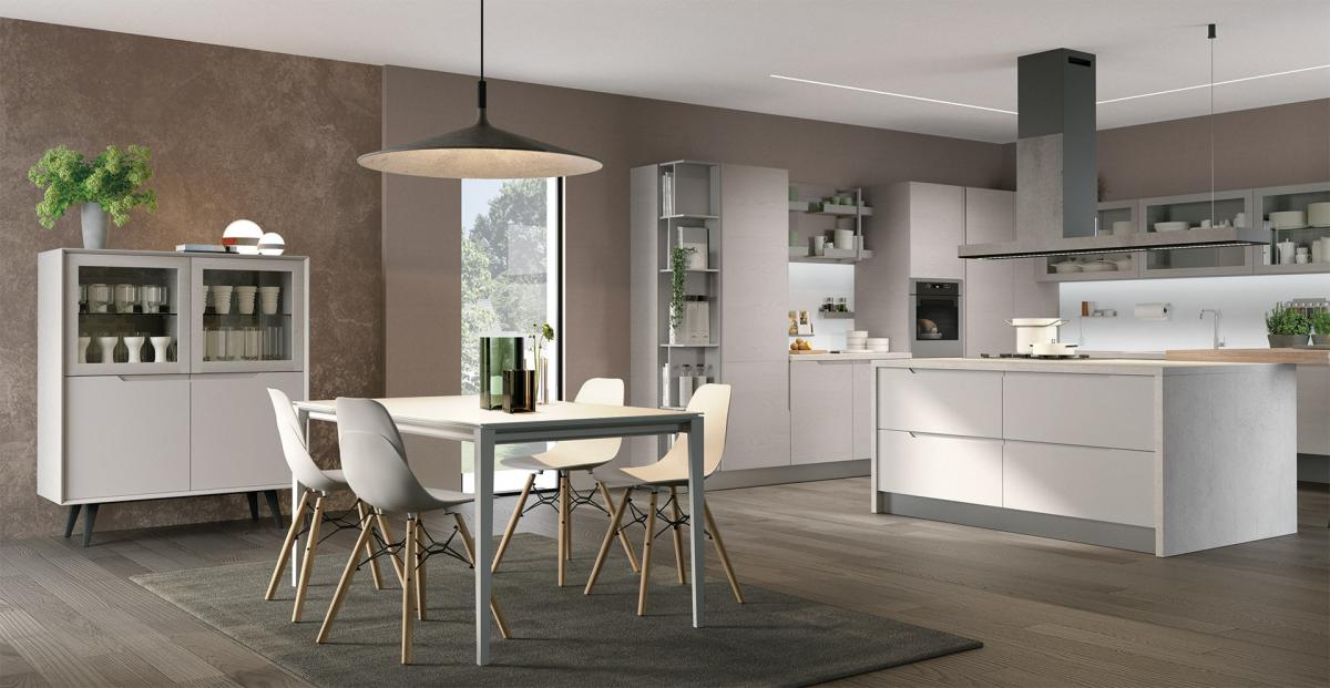 Cucina e sala da pranzo moderne con mobili bianchi e grigi, isola e tavolo.