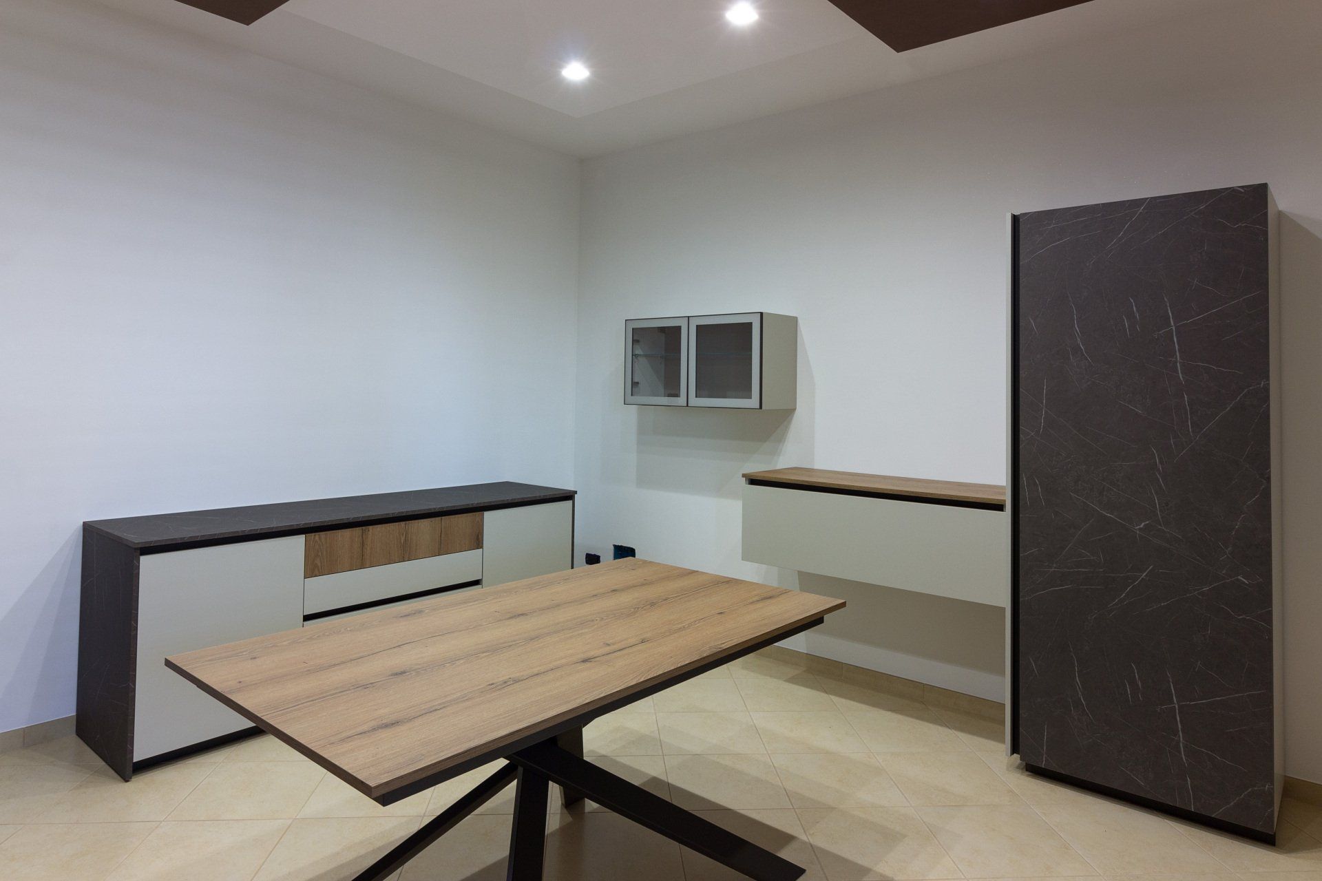 Moderna sala da pranzo con tavolo in legno, mobili scuri e pareti dai colori neutri.