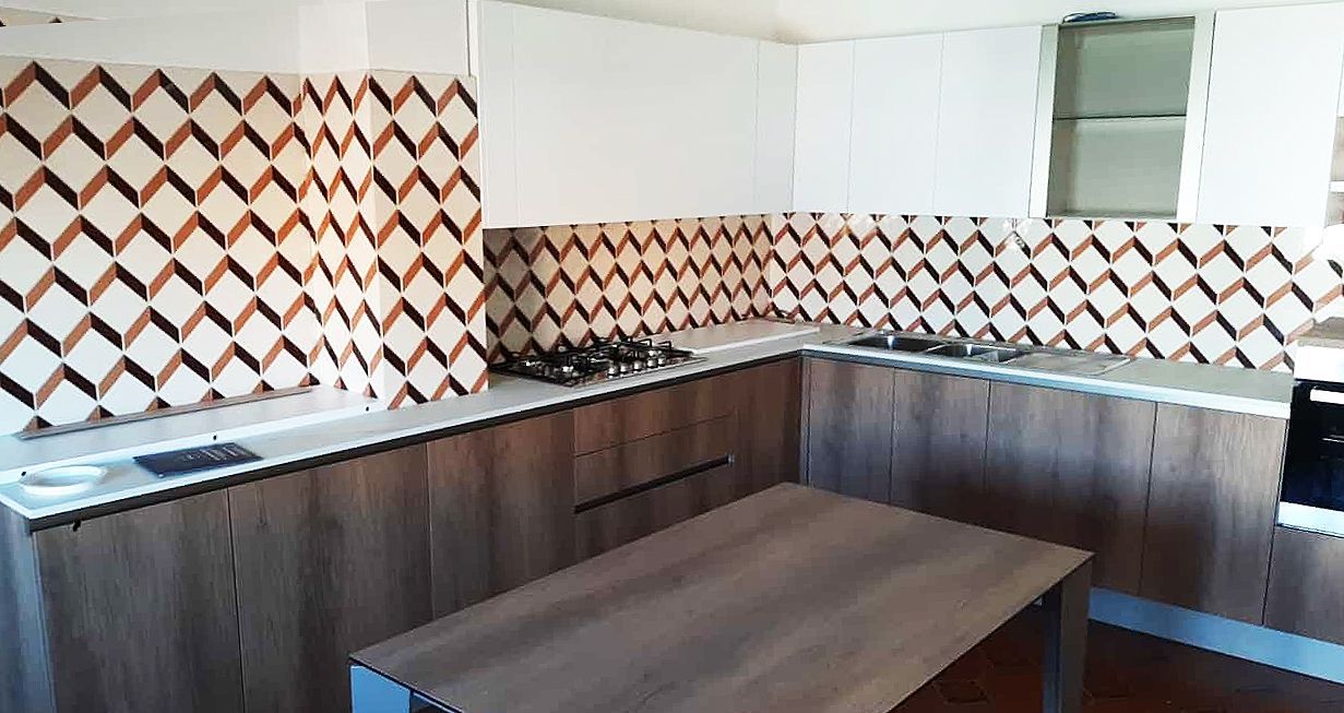 Cucina moderna con mobili in legno, paraschizzi decorato e tavolo in legno.