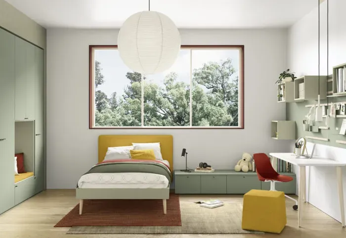 Camera da letto con letto, scrivania e armadio nei colori verde e giallo; grande finestra con alberi.