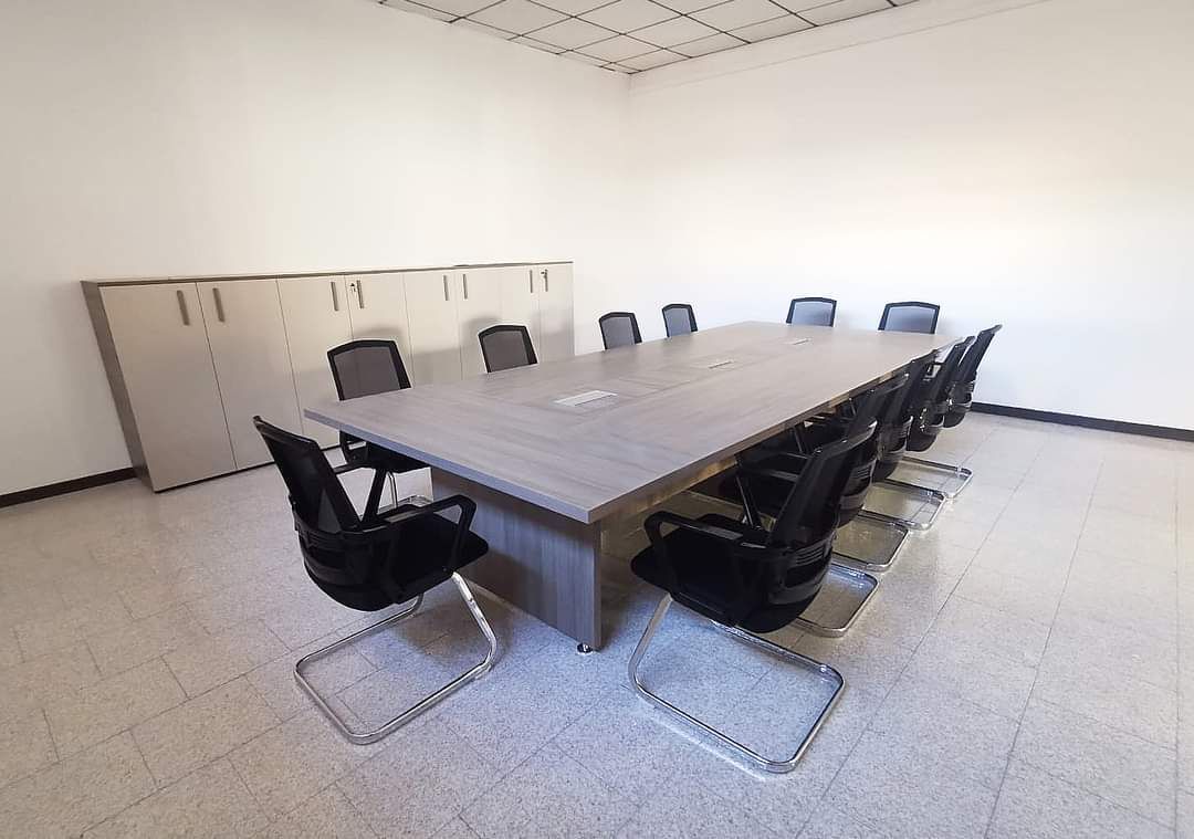 Sala conferenze con un grande tavolo e sedie. Armadietti lungo le pareti.