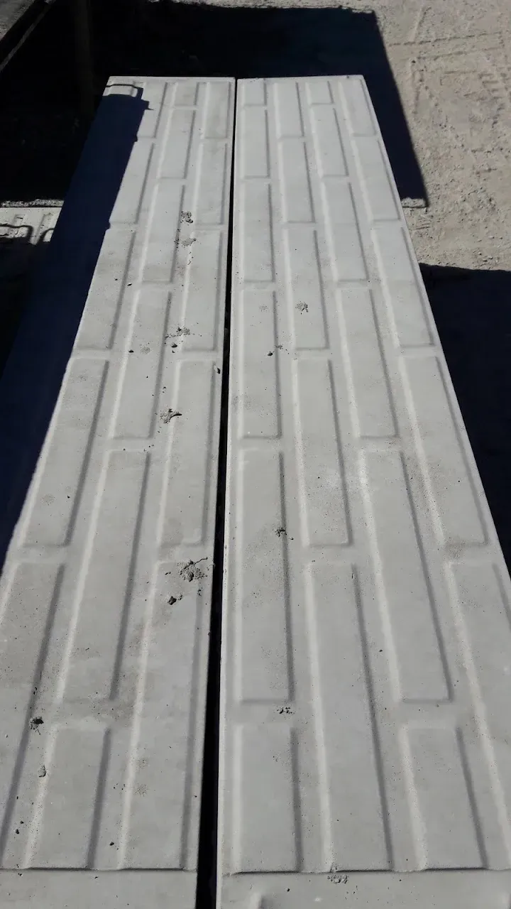 Pasarela o rampa blanca con textura que conduce a una abertura oscura, vista desde arriba.