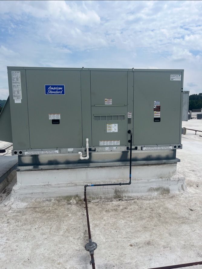 Large gray utility transformer on a concrete pad outdoors under a cloudy sky