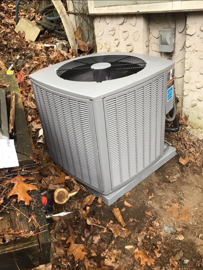 Attic HVAC unit with insulated ductwork and exposed beams under a low ceiling
