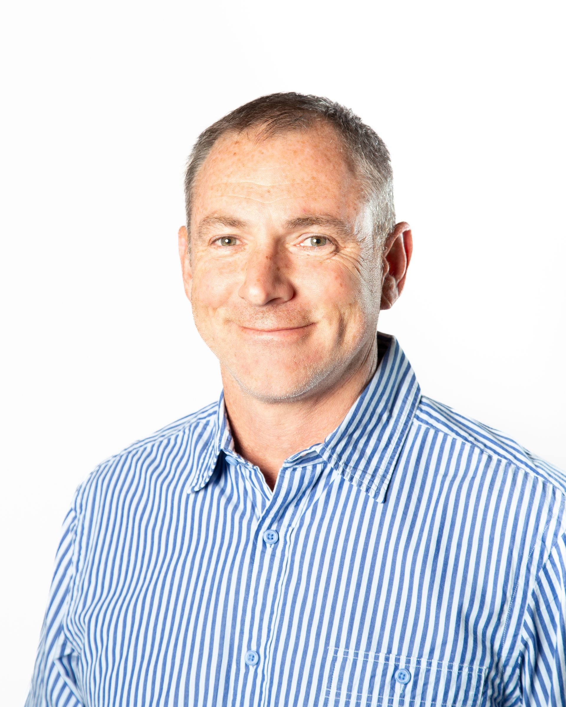 Man in blue striped shirt smiling against a white background