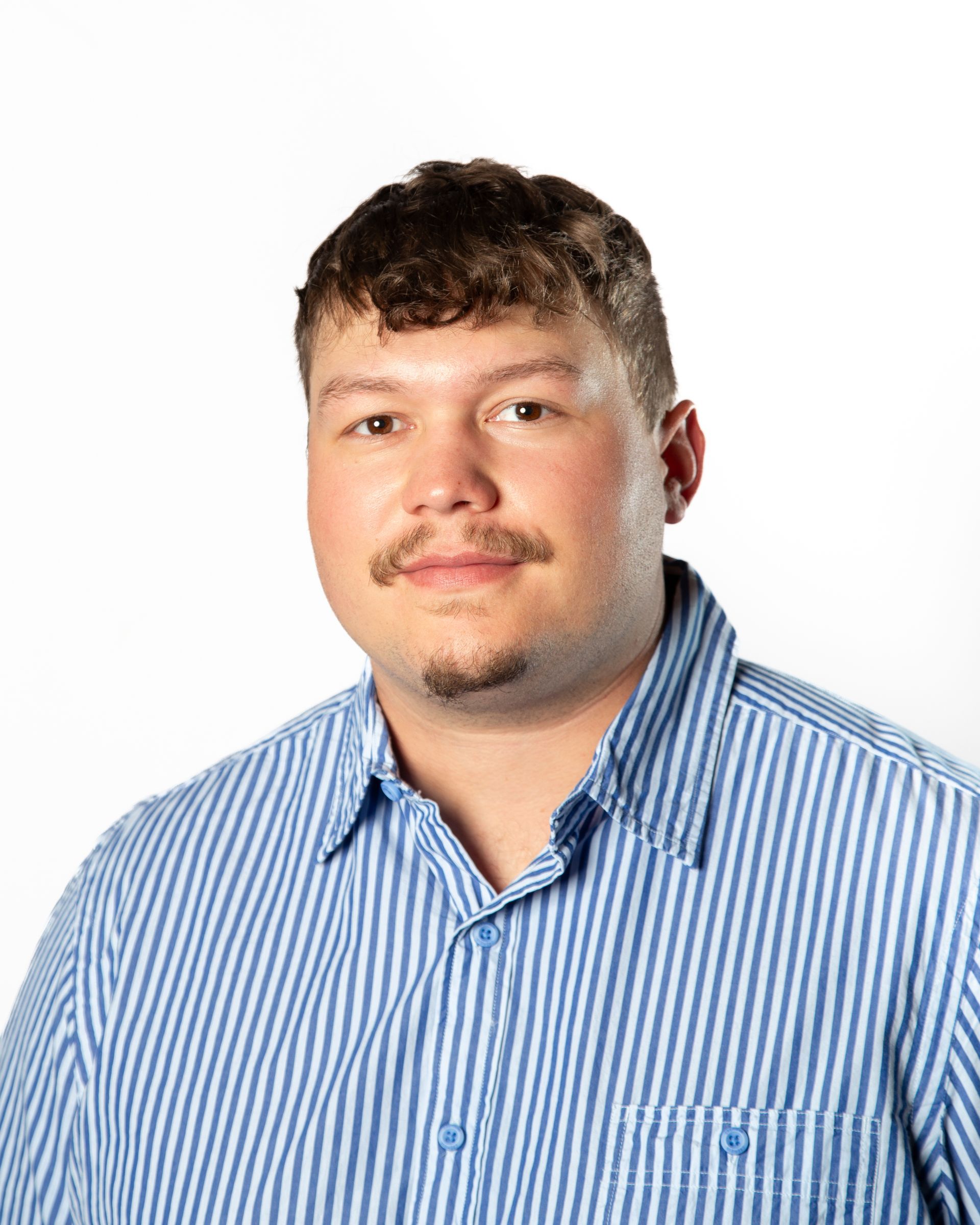 Portrait of a man in a blue striped button-up shirt on a white background
