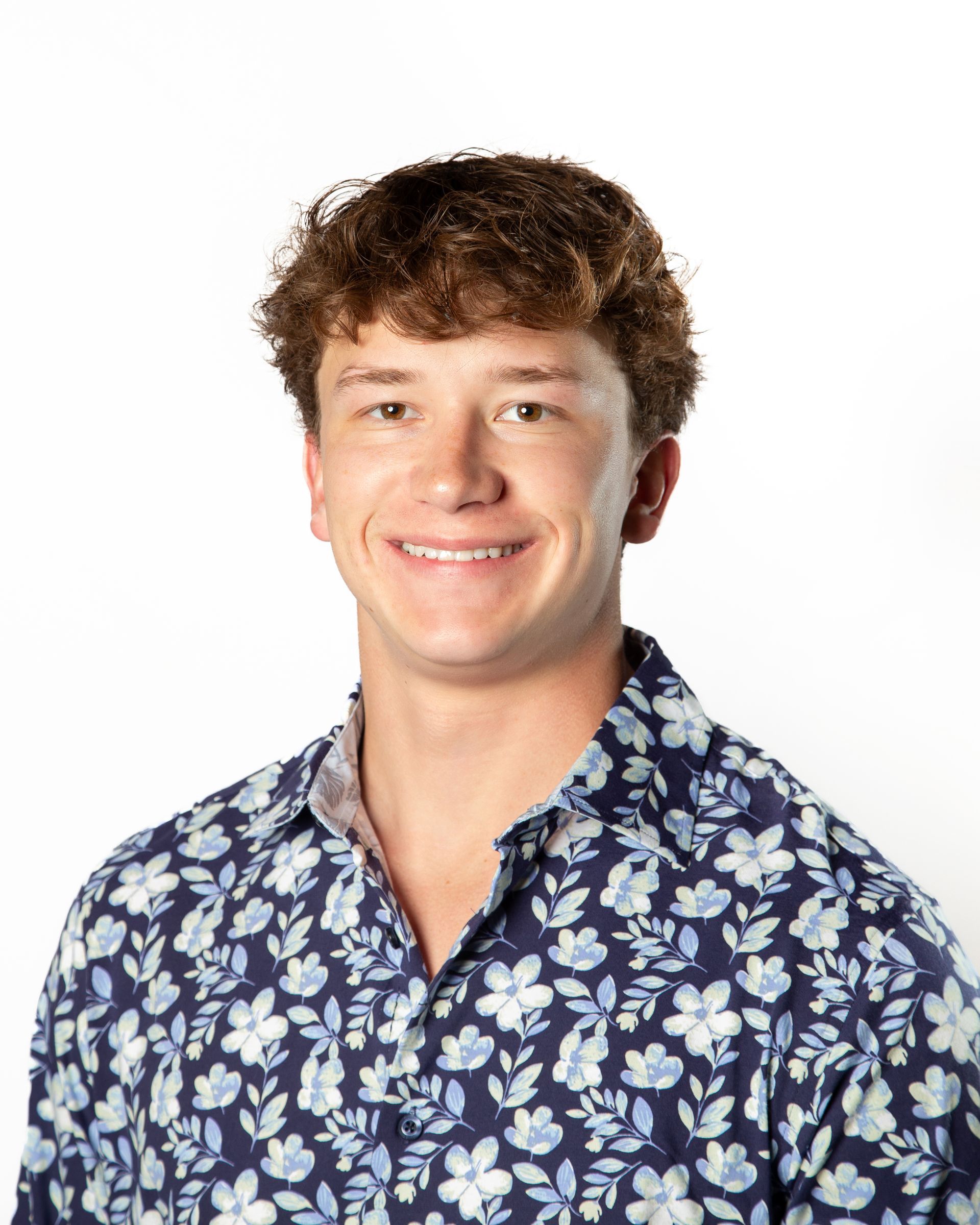 Smiling person in a blue floral shirt against a white background