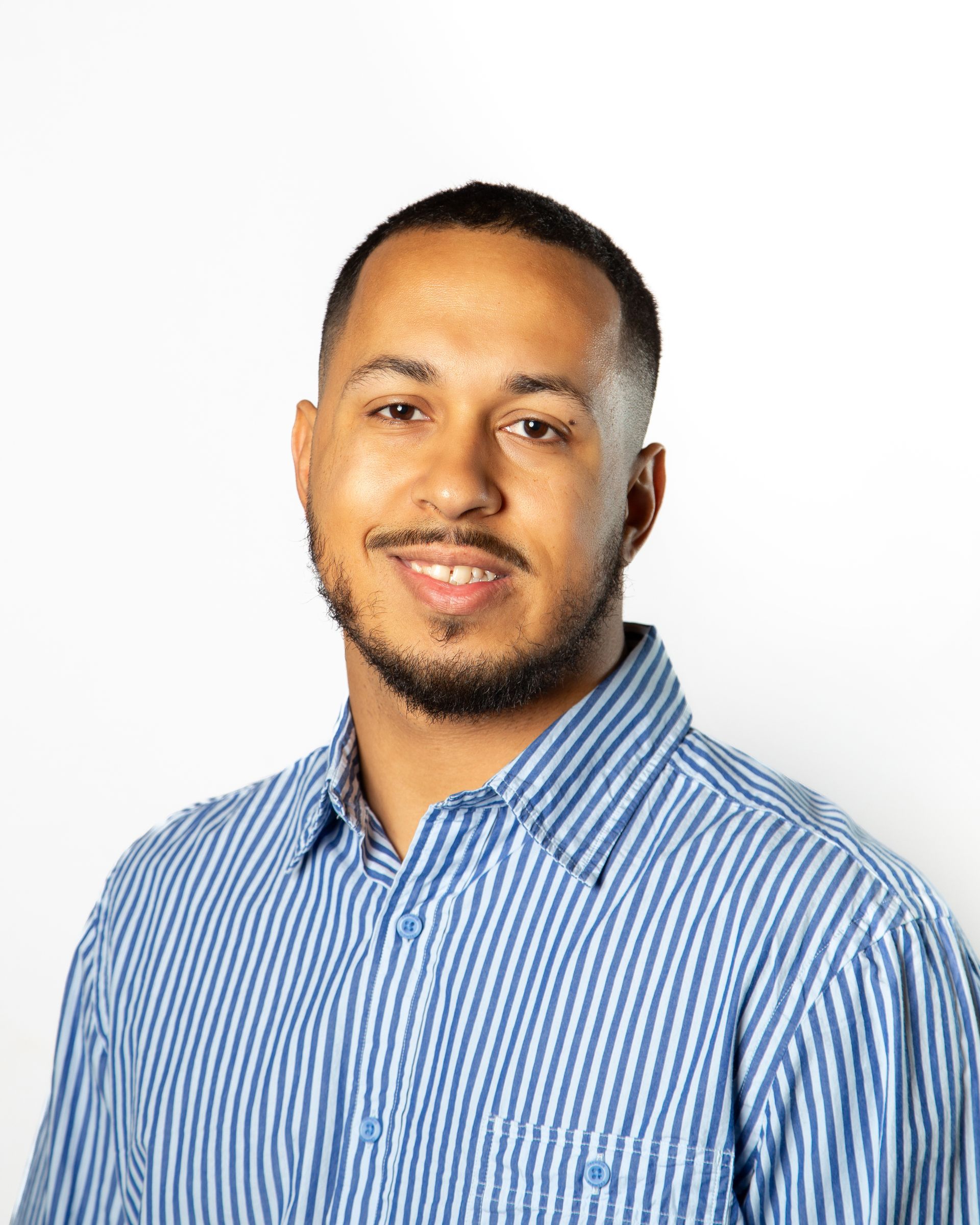 Smiling man in a blue striped button-up shirt against a white background