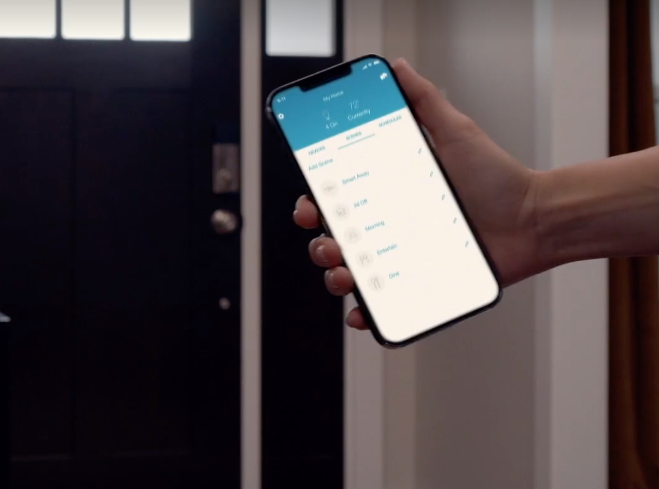 Hand holding a smartphone with a blue app screen in a dim hallway