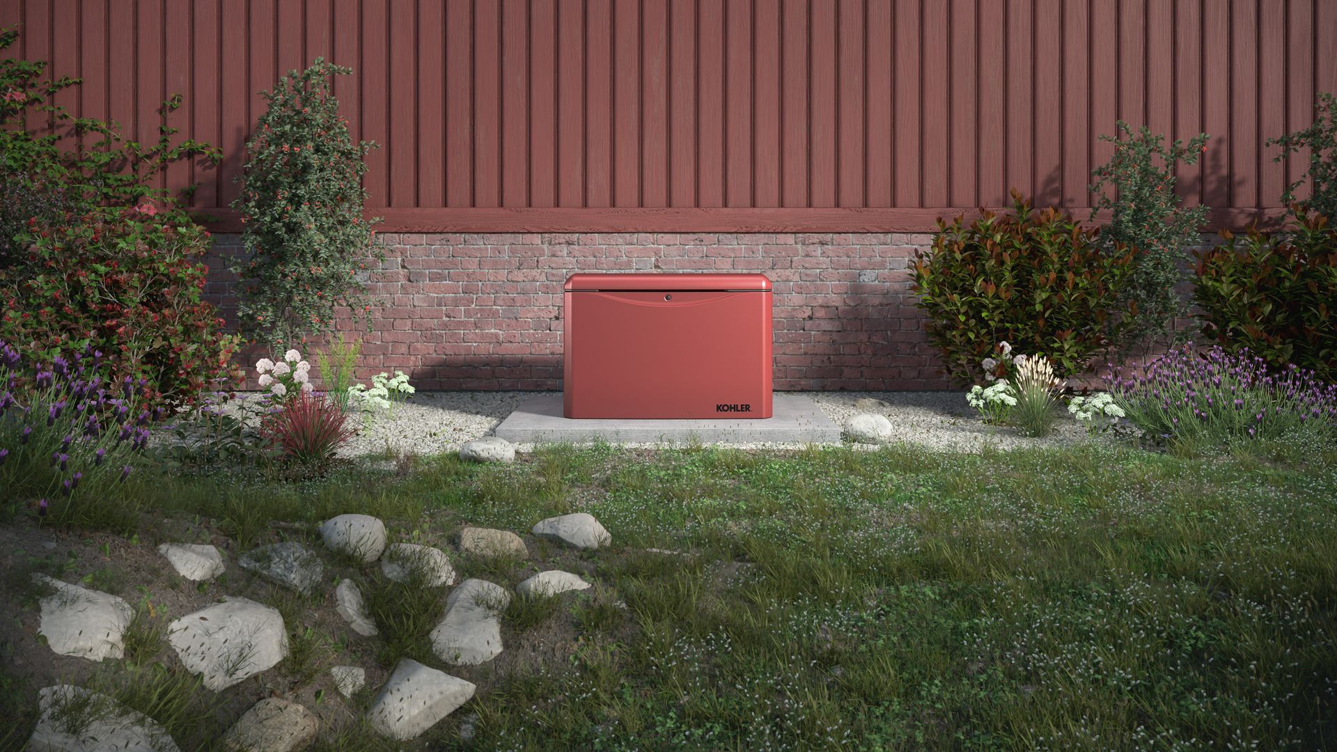 Red utility box centered in a garden bed against a red siding wall, with rocks, shrubs, and flowers.