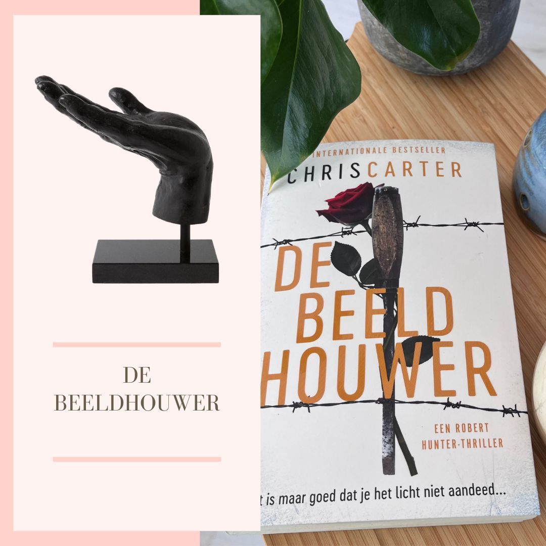 Zwart handsculptuur en een boek getiteld 