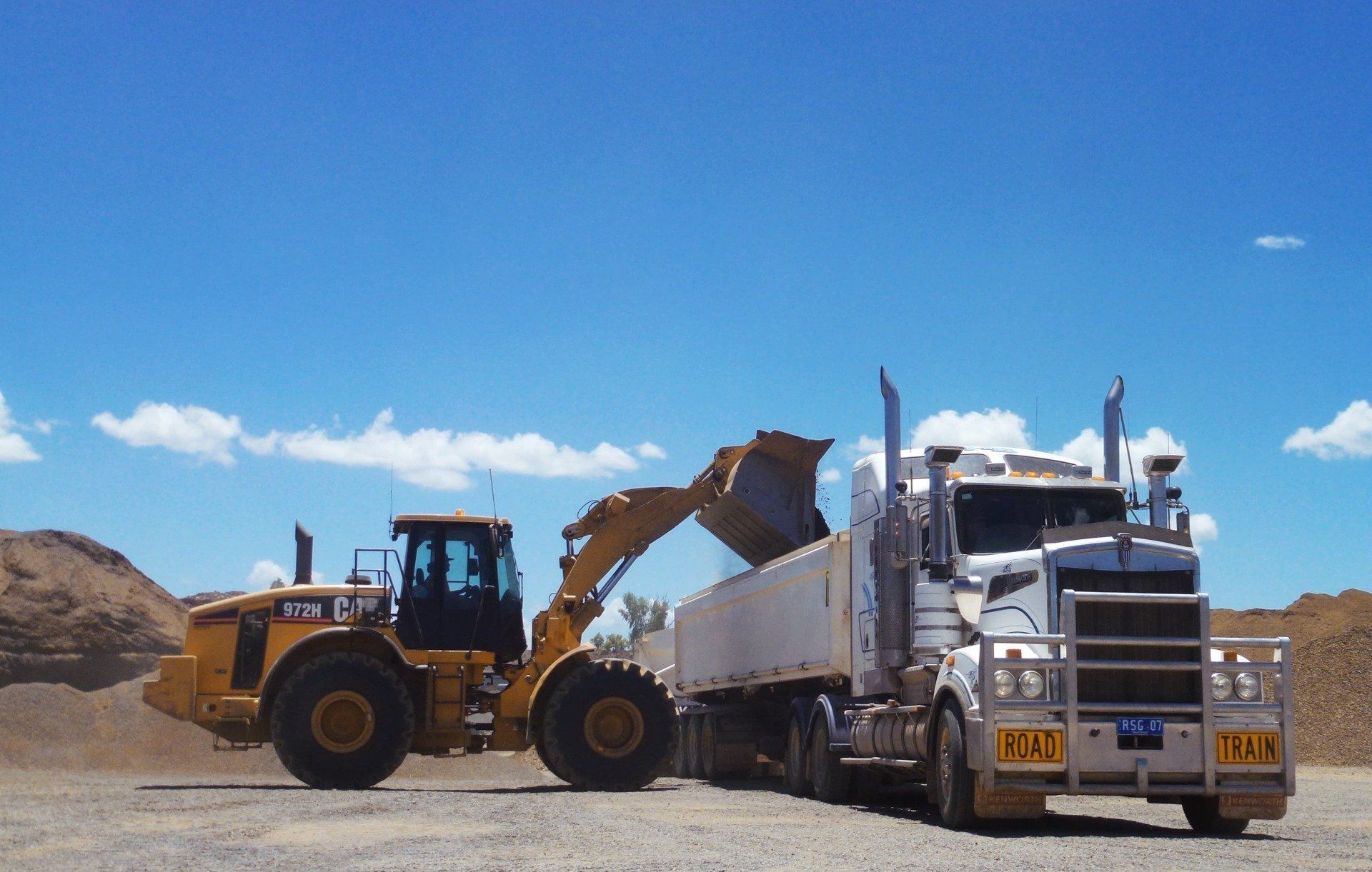 Tractor Filling Delivery Truck With Crushed Rock — Quarry Products In Moranbah, QLD