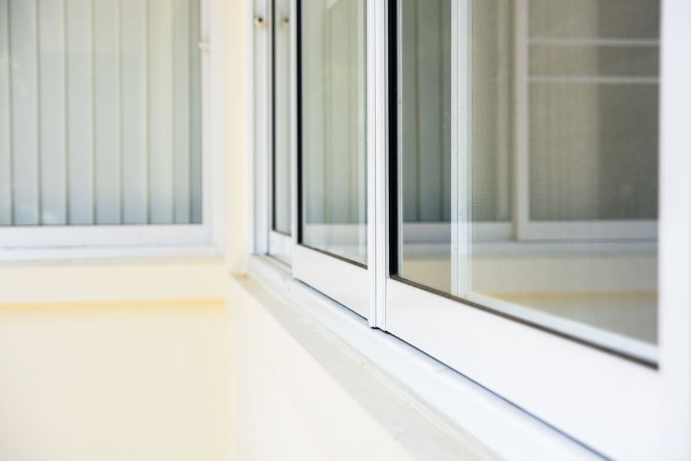 White Framed Sliding Windows on a Cream-colored Building — A1 Security Screens Cairns In Edmonton, QLD