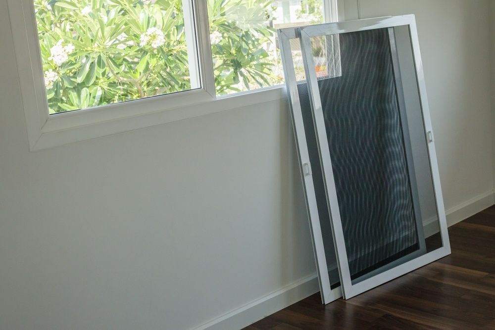 A Mosquito Screen is Sitting on the Floor Next to a Window — A1 Security Screens Cairns In Manunda, QLD