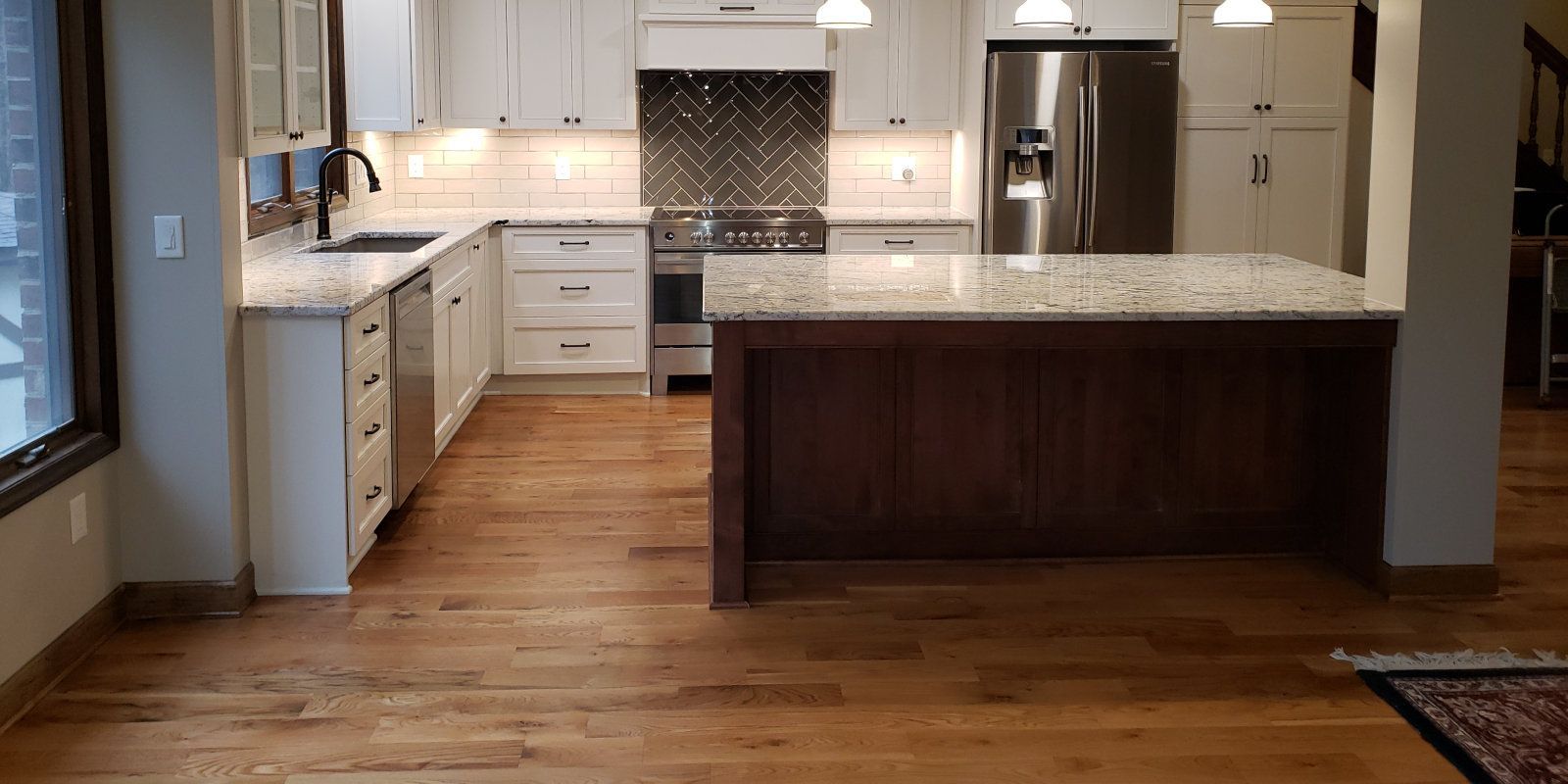 Modern kitchen with white cabinets, wood island, granite counters, and hardwood floors