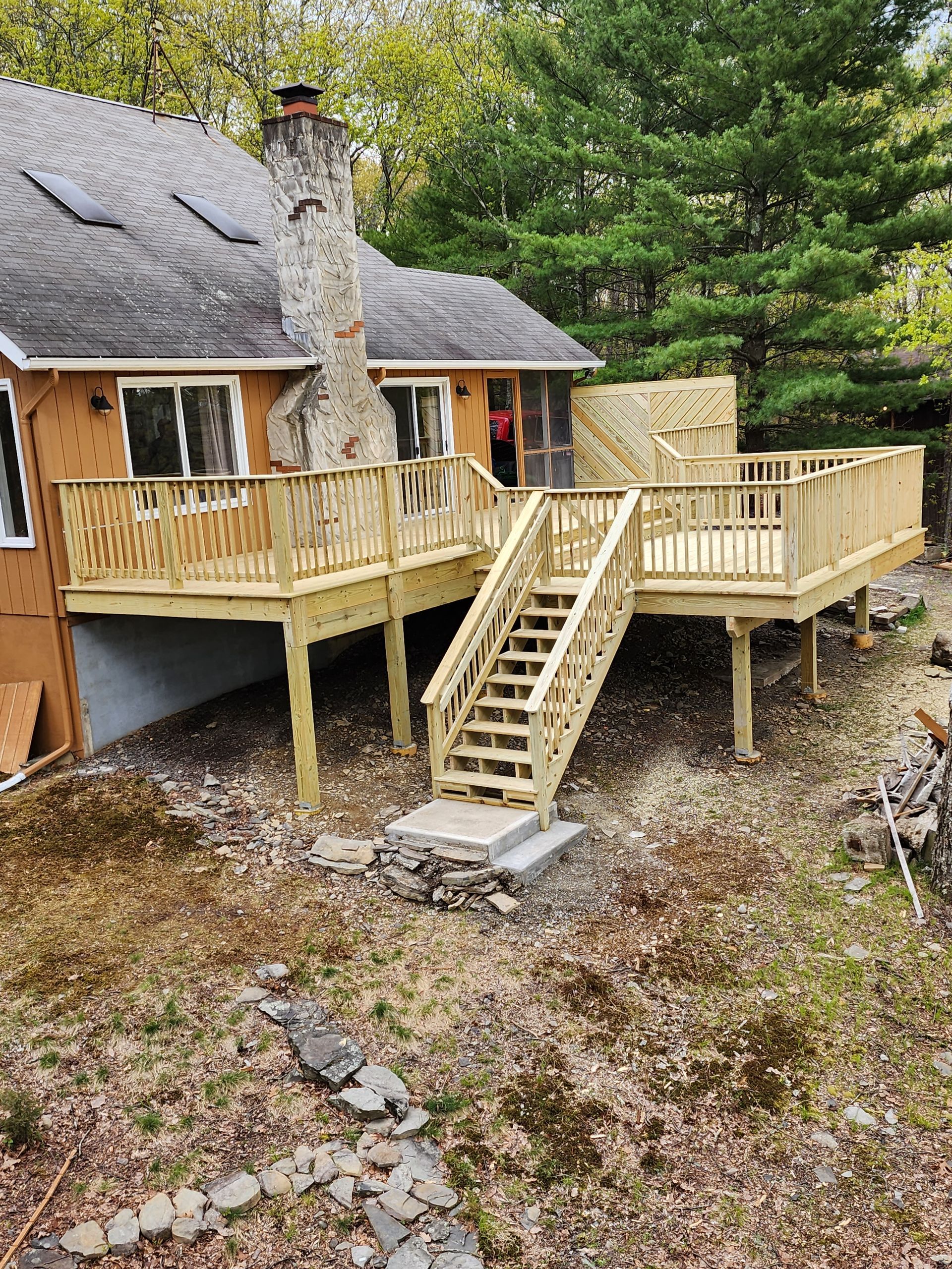 A house with a wooden deck and stairs in front of it.