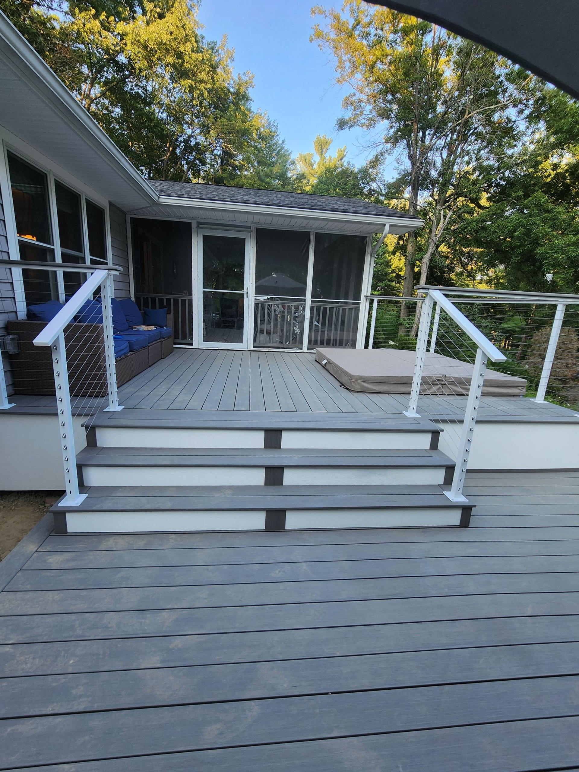 A man is kneeling on a wooden deck under construction.