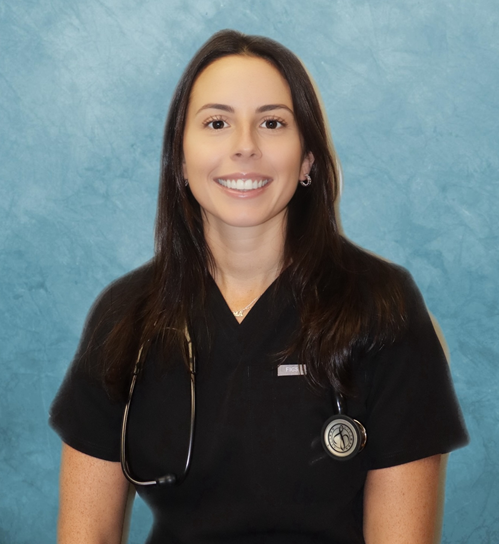 Woman in black scrubs, stethoscope around neck, smiling.