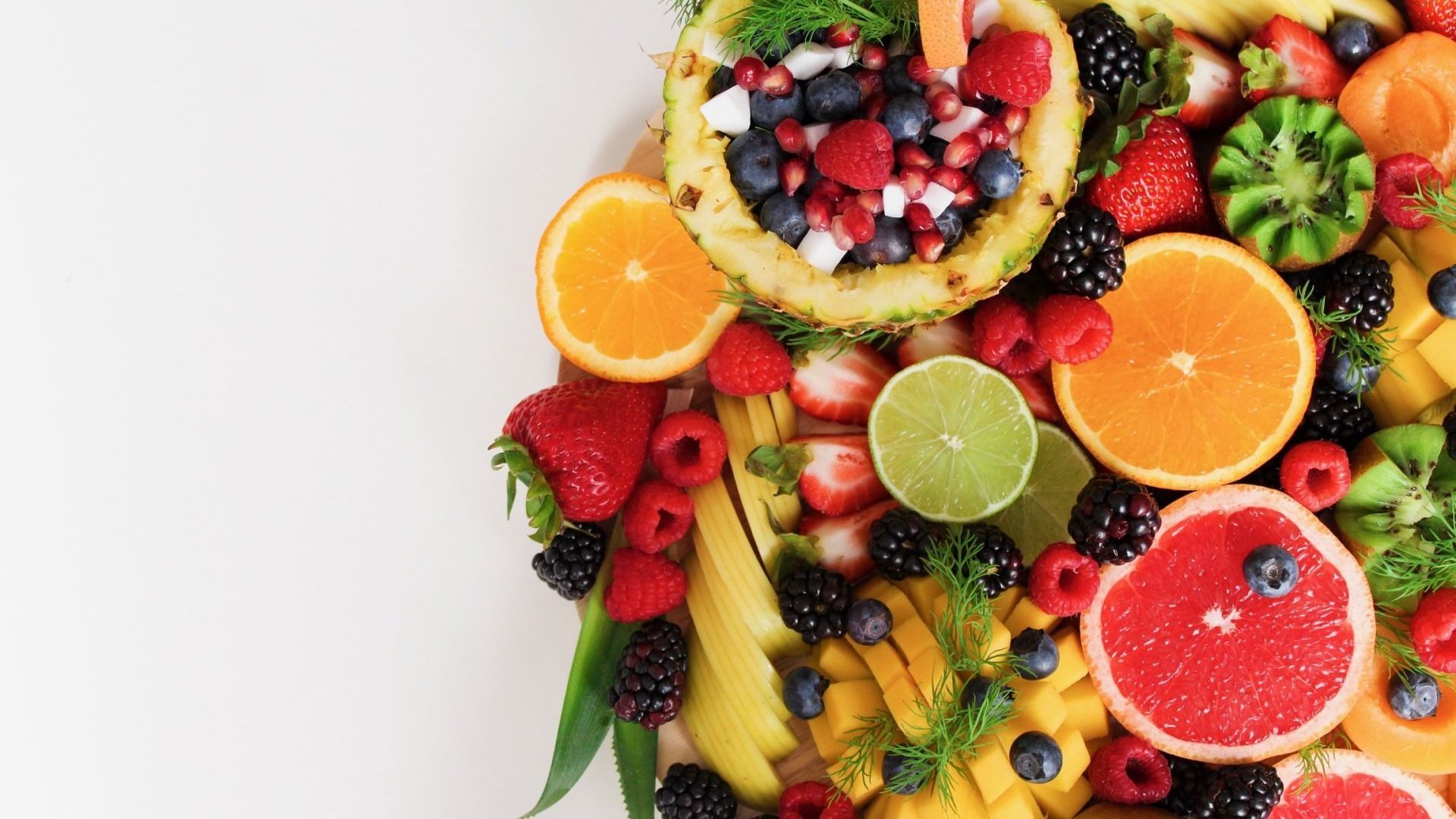 Ein weißer Teller mit verschiedenen Früchten und Beeren.