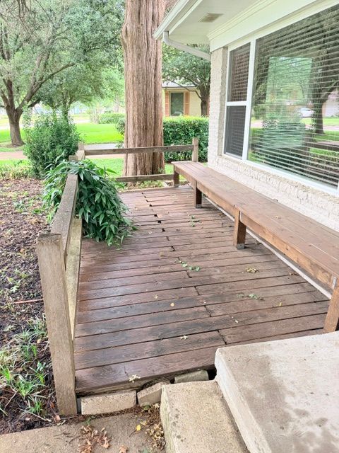 Before photo of an aging cedar deck with weathered wood boards, built-in bench, and railing at a Dallas, TX home.
