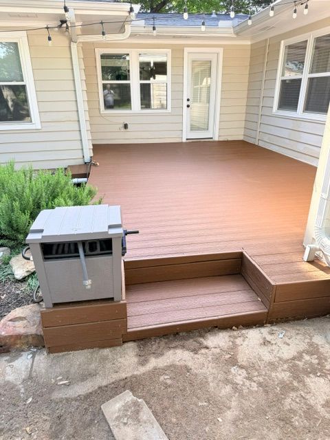 After photo of a renovated backyard deck with rich brown decking, matching steps, and a refreshed patio area in Dallas, TX.