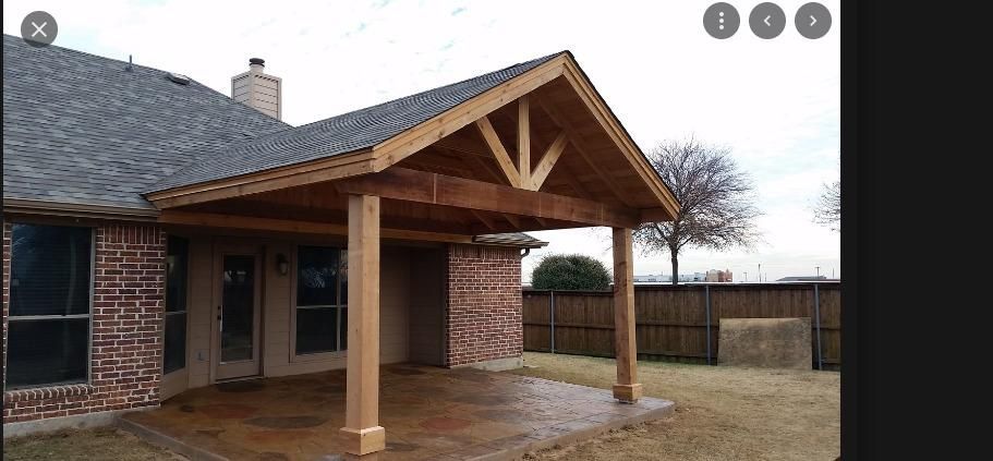 Brick house with covered front porch, wooden gabled roof, and wet patio in a suburban yard