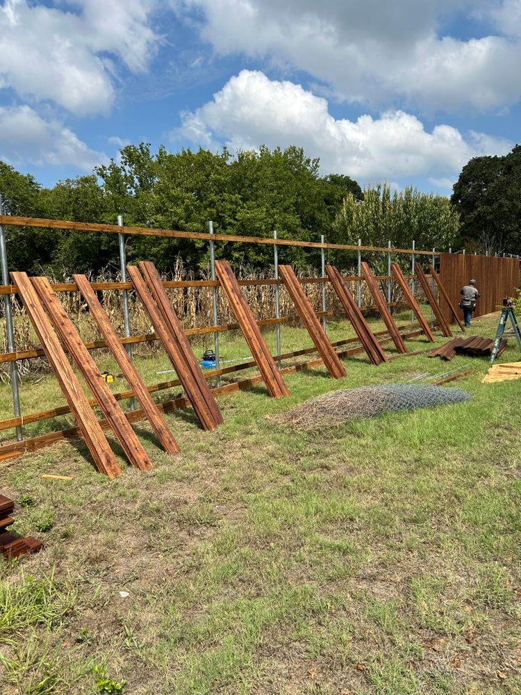 Wooden outdoor climbing frame under construction on a grassy field with blue sky and trees