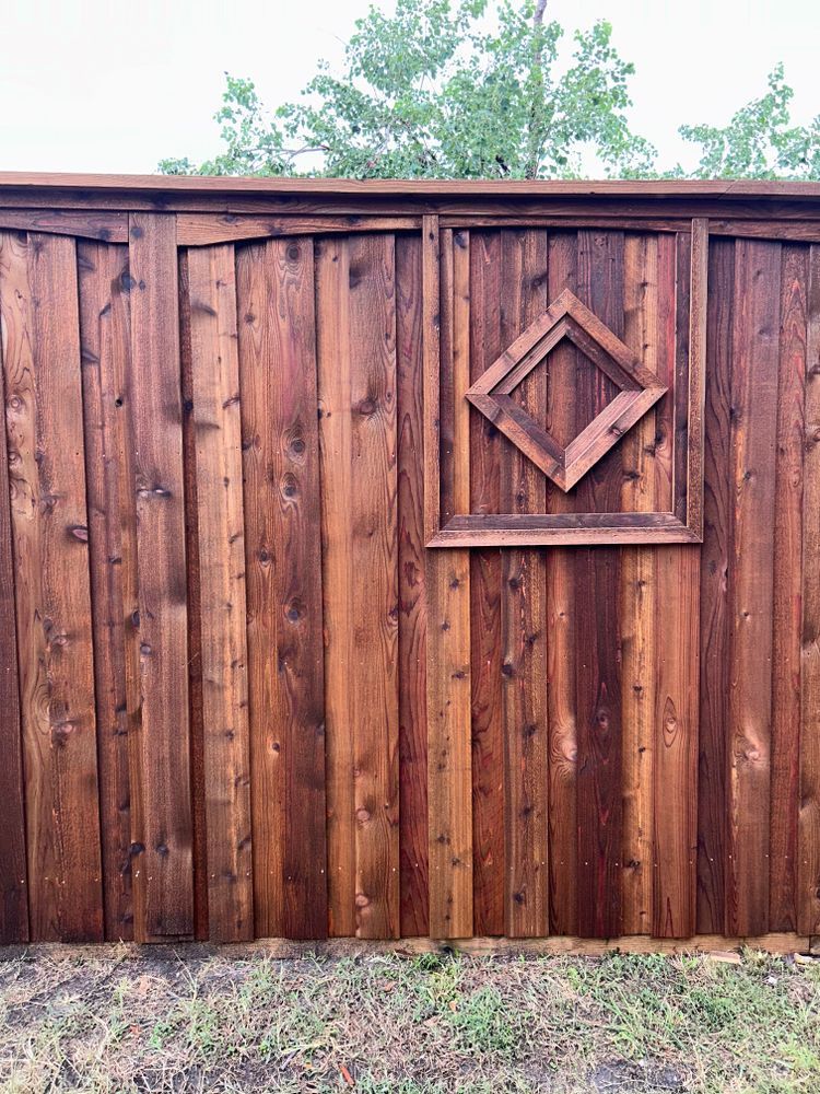 Wooden fence with a diamond-shaped decorative panel and grass in front
