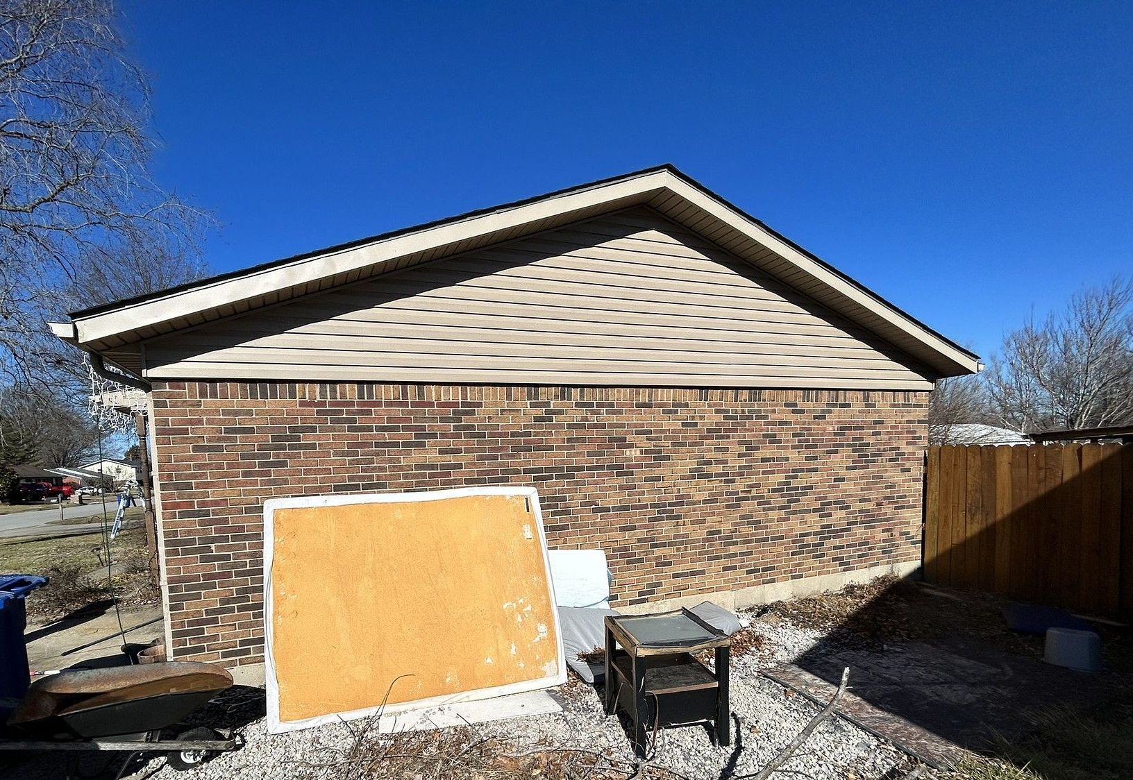 A brick house with a roof that is being remodeled.