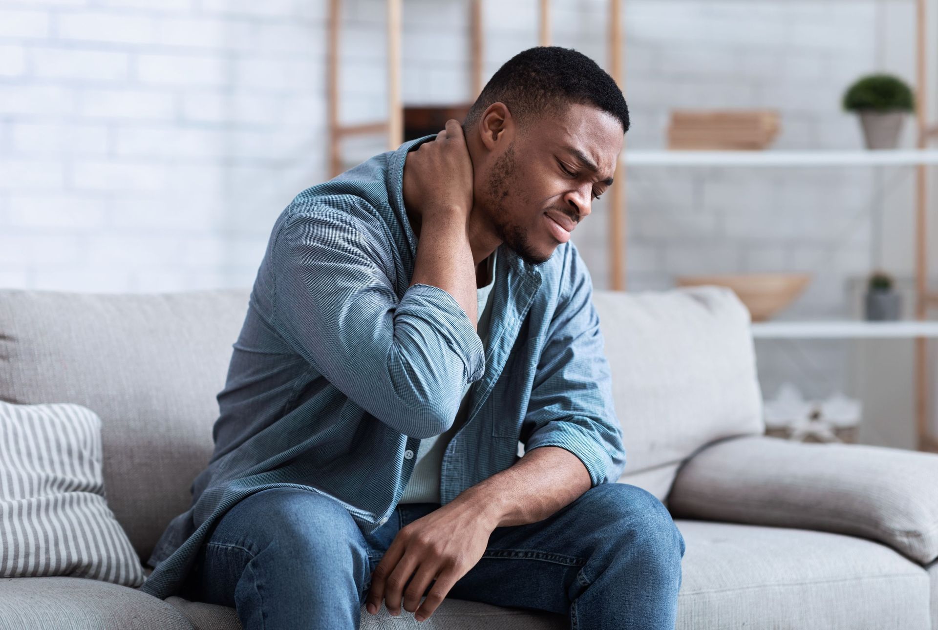 black man suffering neck pain massaging