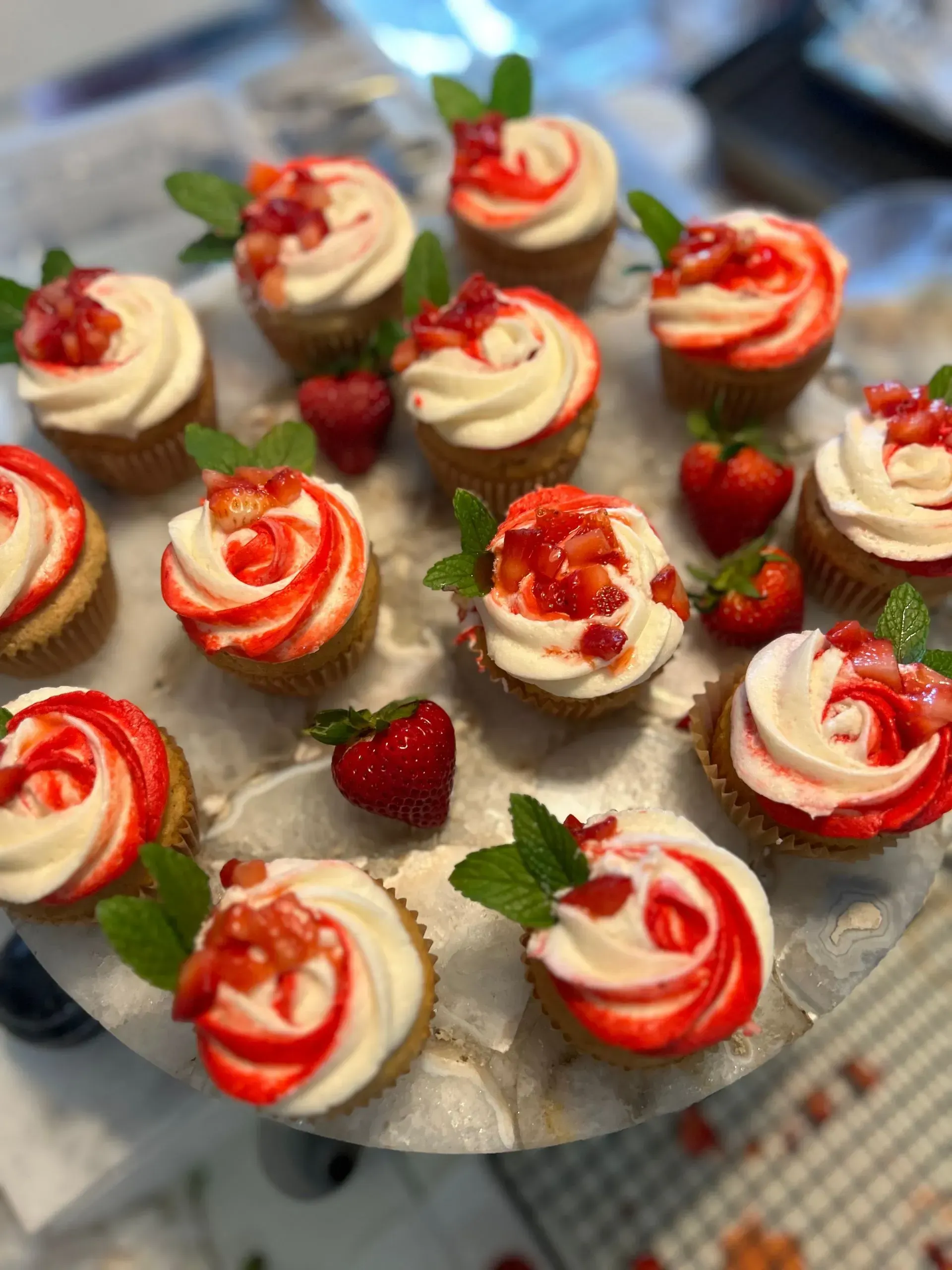 Mini strawberry and cream tartlets topped with strawberry sauce on a serving tray