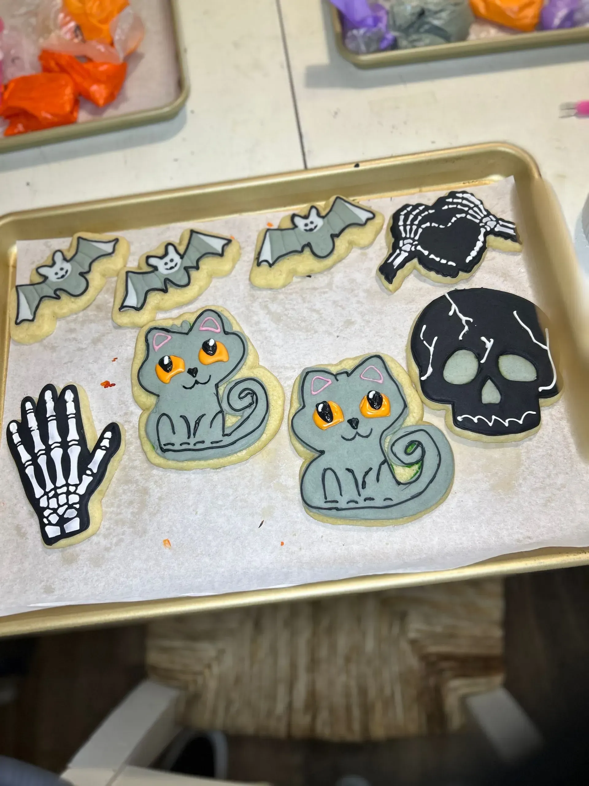 Halloween cookie tray with cat, bat, skull, spider, and skeleton hand cookies decorated in black, white, and gray