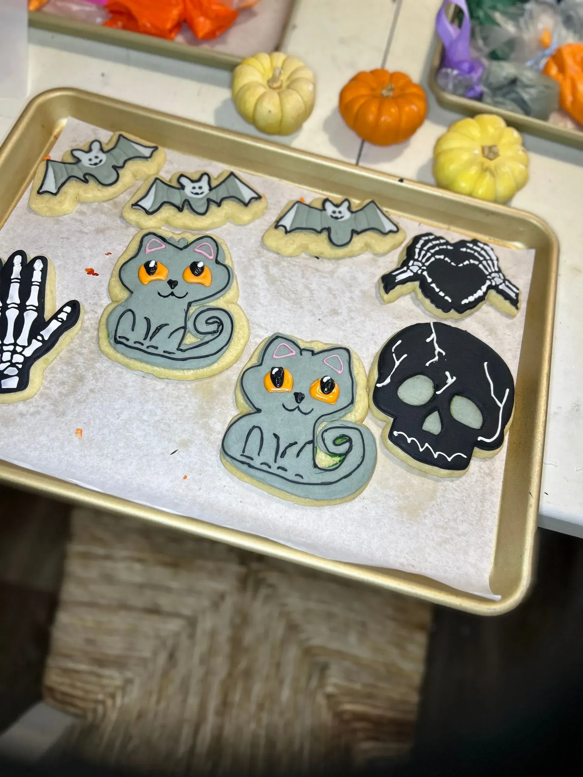 Halloween cookie tray with skulls, bats, and jack-o'-lantern treats on parchment paper