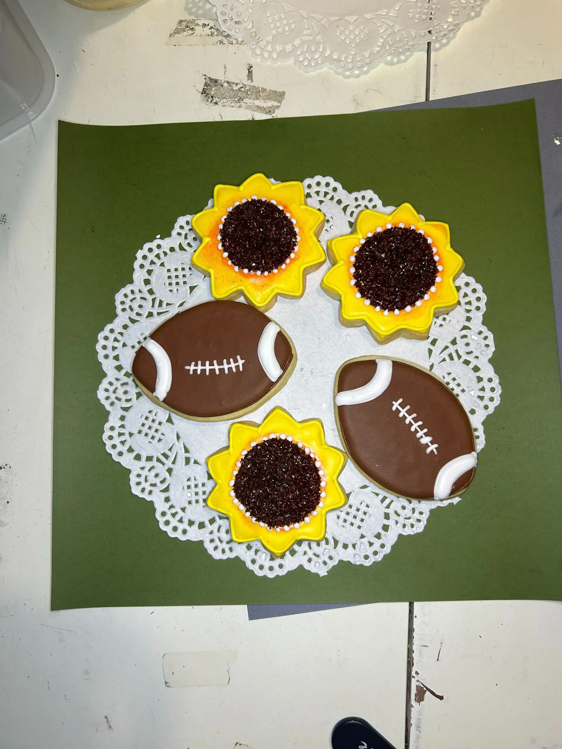 Paper football and sunflower craft on green background