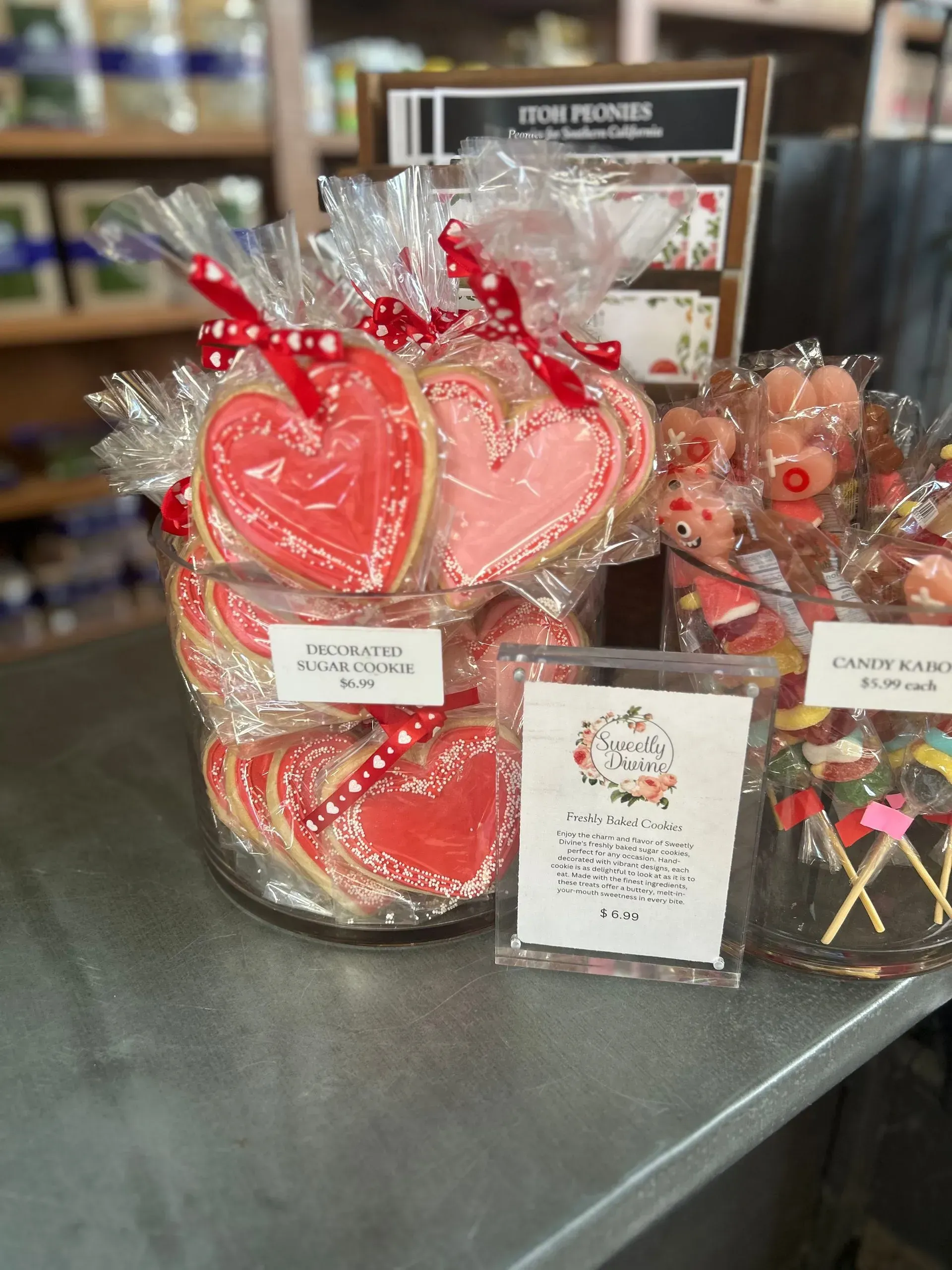 Heart-shaped candy gift bags tied with red ribbons on a store counter.