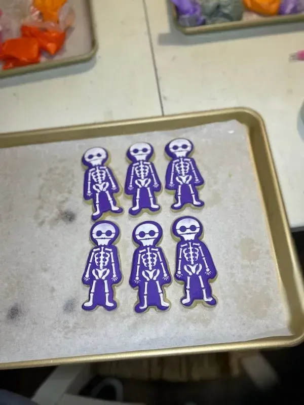 Six purple skeleton stickers arranged in two rows on a tray.