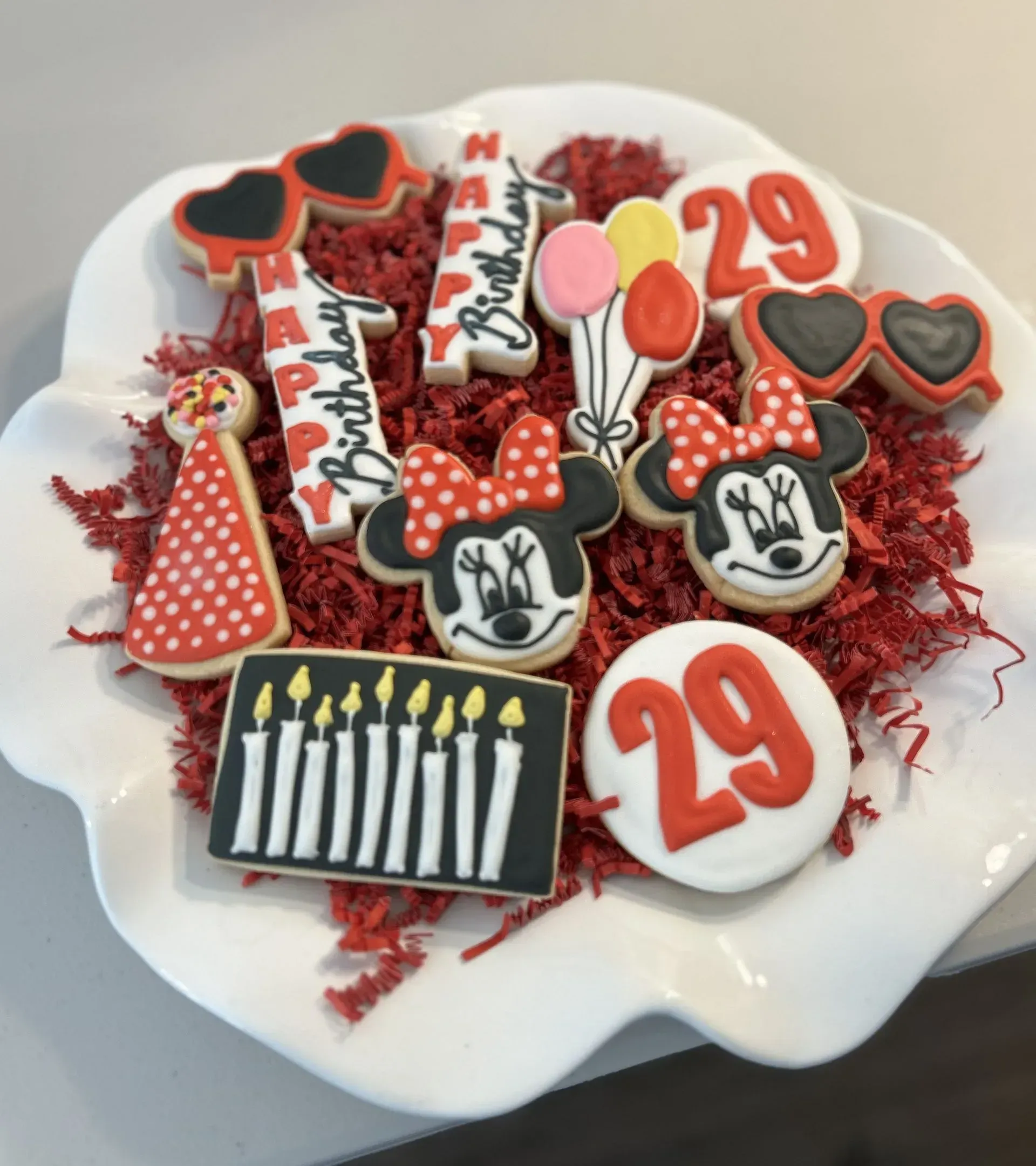 Mickey and Minnie-themed birthday cookie arrangement with red, white, and black cookies and a “29” topper